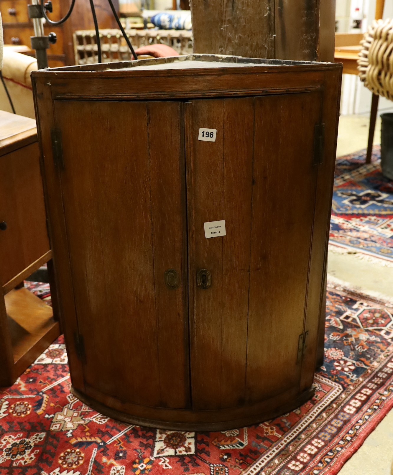 A George III oak bowfront hanging corner cabinet, width 62cm, depth 44cm, height 79cm